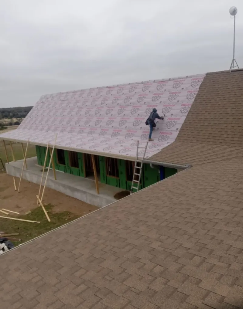 Worker preparing underlayment for a metal roof installation in Beavercreek